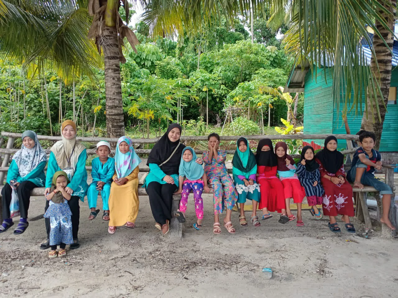 guru wanita Yayasan Ikhlas bergambar bersama anak-anak pulau di Sabah.